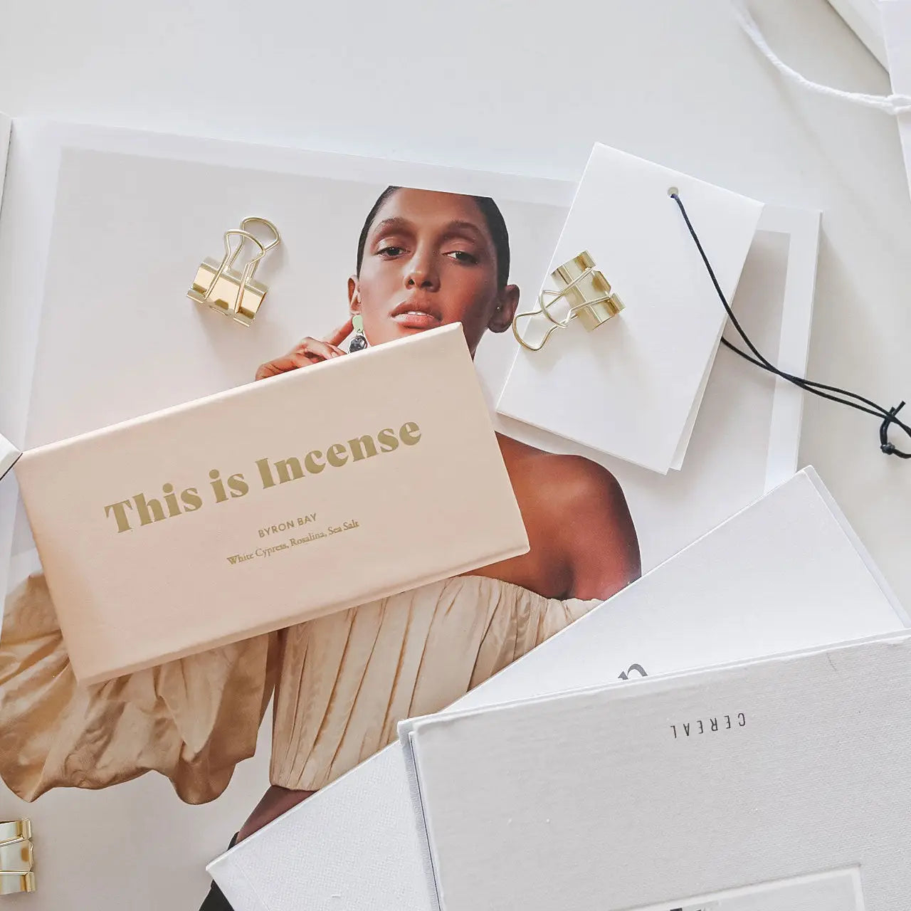 “Byron Bay incense box styled with fashion magazine and accessories in a soft aesthetic layout”