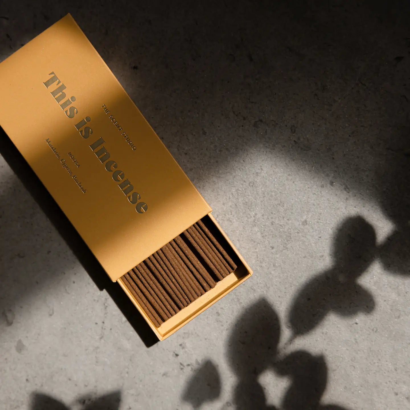 Open incense box with sticks shown in warm natural lighting