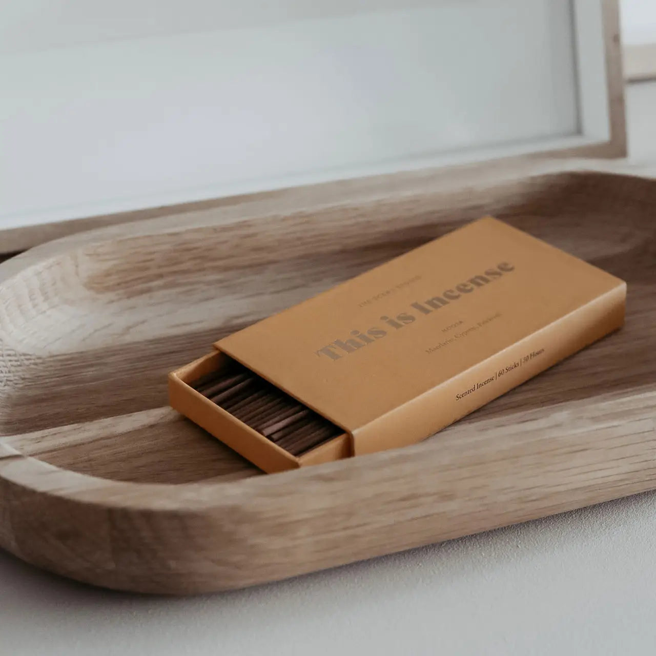 Incense box in warm citrus orange tone placed on a wooden tray