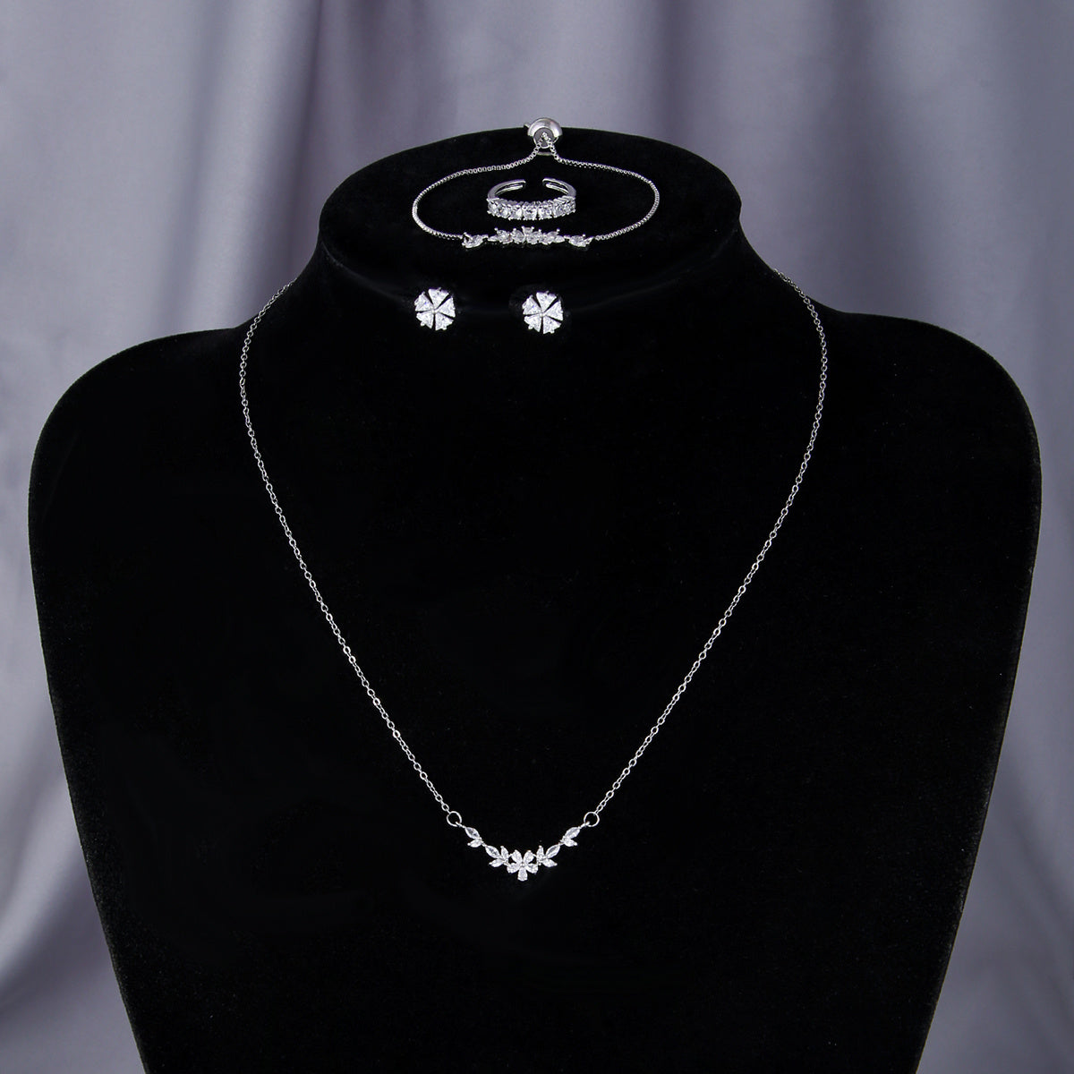 “Silver zircon necklace displayed on black bust mannequin for jewelry presentation”