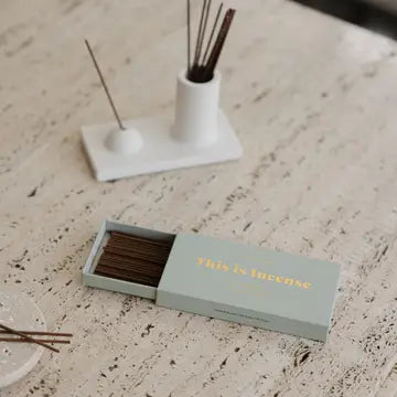“Incense sticks burning in a white ceramic holder beside Margaret River packaging”